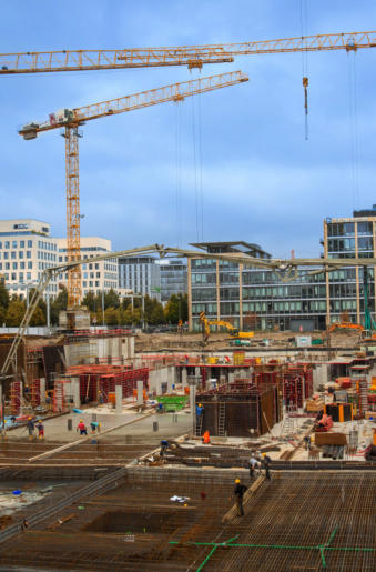 Microsoft Deutschland-Zentrale - ein Großbaustelle im Rohbau mit Stahlbewehrungen und großen Kränen, Hochhäuser im Hintergrund